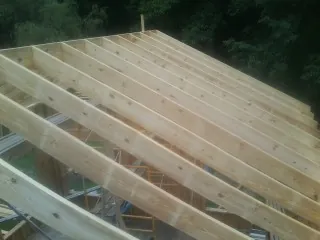 New roof rafters set over an addition before sheathing in Easton